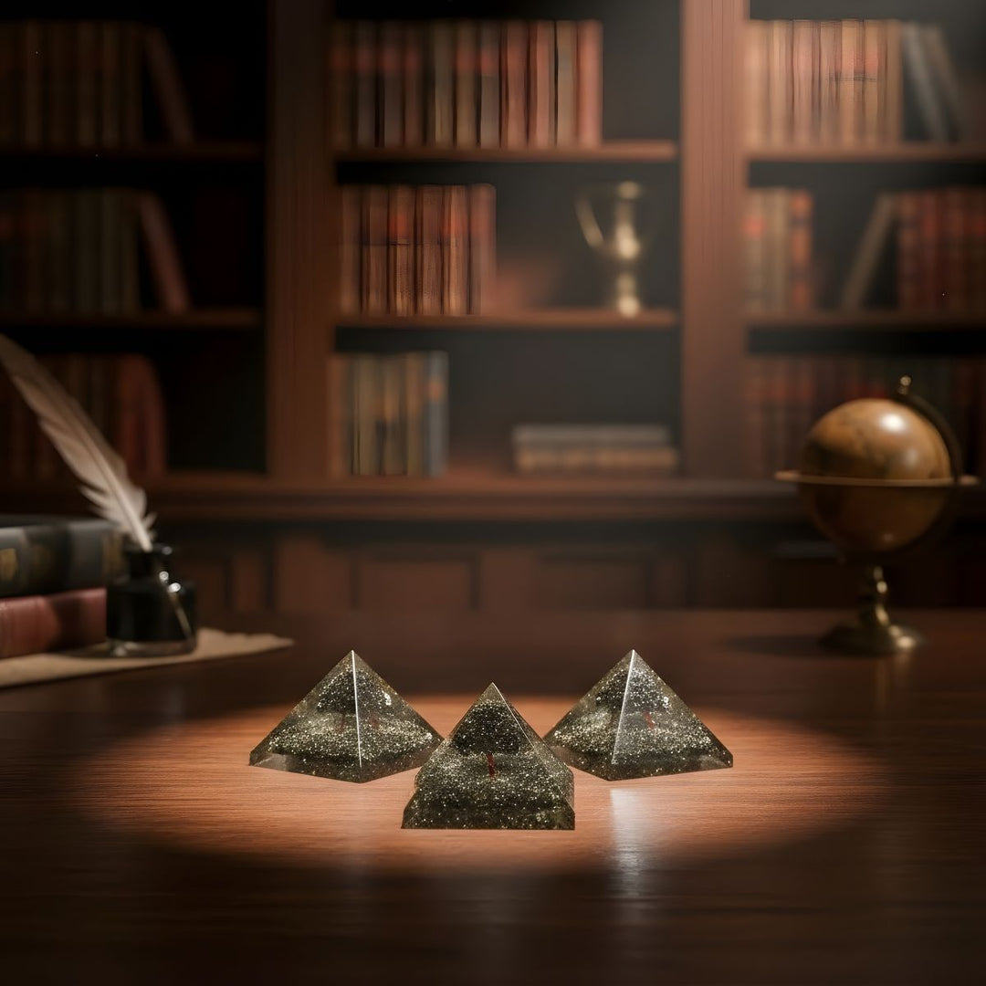 Three crystal pyramids on a wooden surface with bookshelves and a globe in the background